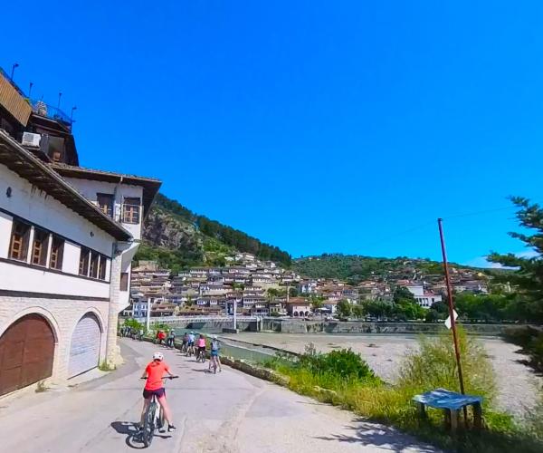 Cyclists leaving Berat beside the river during the electric bike tour to Roshnik.